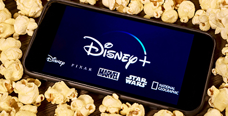 Phone with Disney+ logo sitting on popcorn
