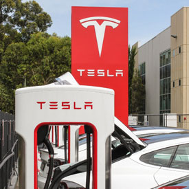 Tesla electric car charging in parking lot