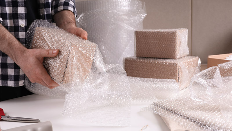 hand wrapping parcels in bubblewrap