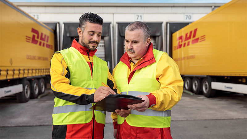 two DHL employees looking at a screen