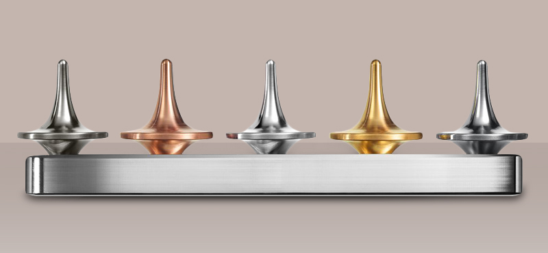 Image_of_five_ForeverSpin_tops_displayed_in_a_matching_machined_metal_top_rack