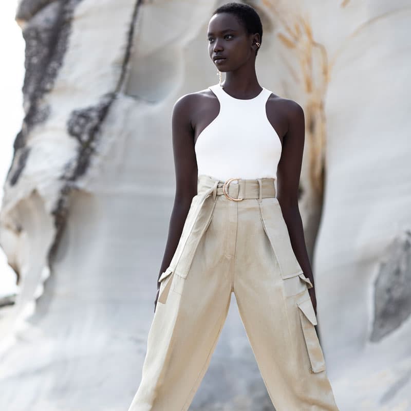 model in a white top and khaki trousers