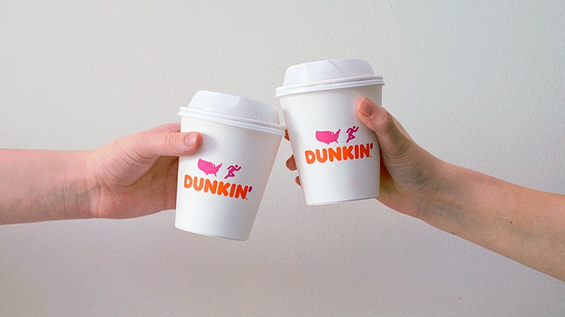 two hands holding dunkin' donuts cups