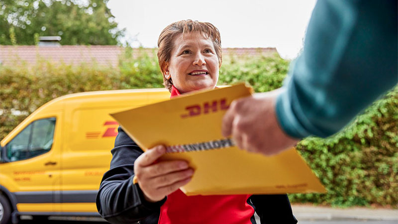 DHL delivery woman handing over a parcel to a man