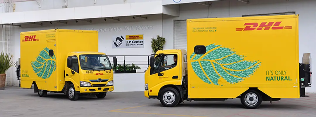 two DHL vans parked in a parking lot