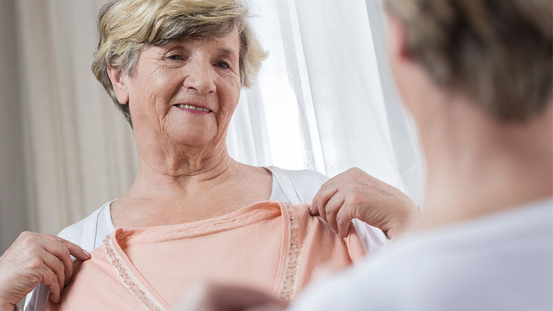 smiling old lady trying on a top