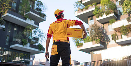 DHL courier holding a DHL parcel