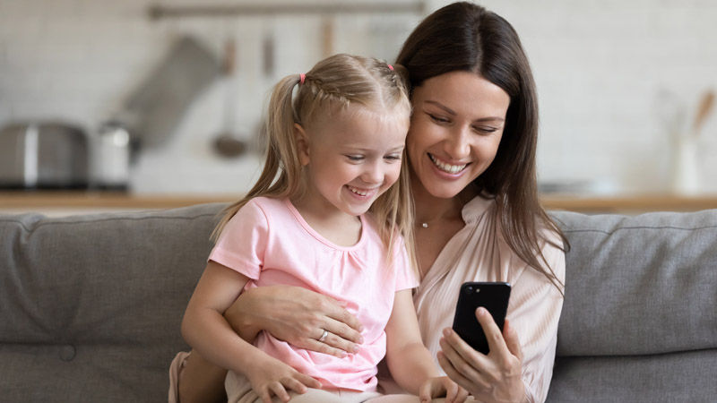 Mum and daughter laughing at a phone