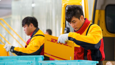 Two DHL staff sorting orders