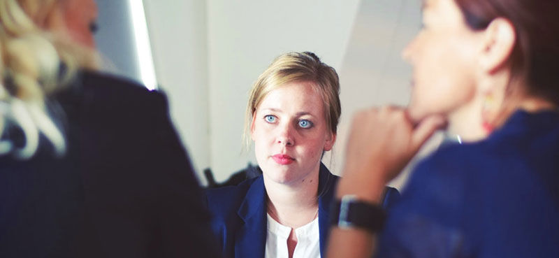 Businesswoman looking at two other business women