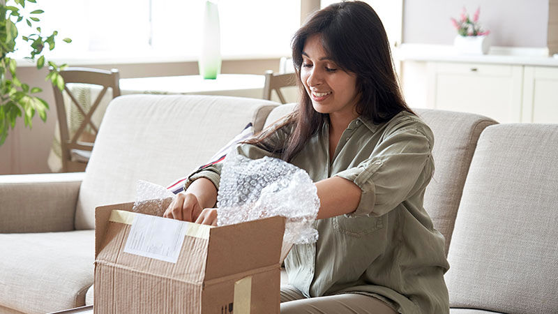 woman packing items into brown box