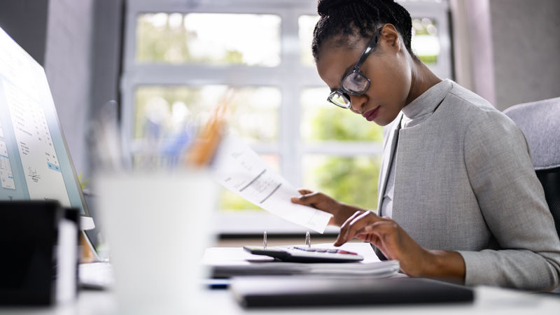 African American Accountant Or Auditor With Calculator