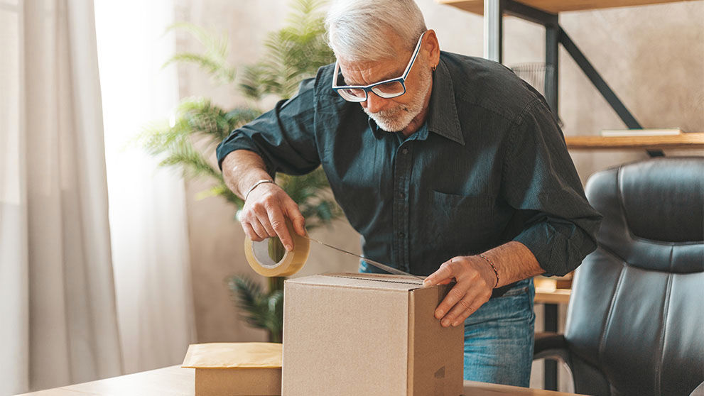 man sealing a brown package