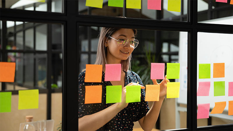 woman putting sticky notes on a window