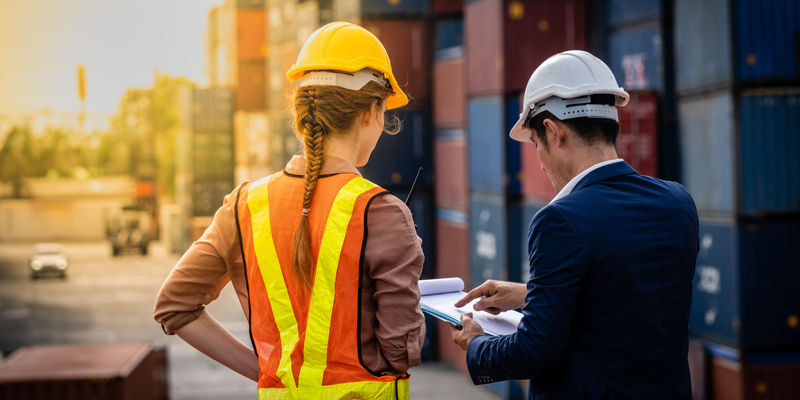 Container Depot chief talking to female foreman about custom document of the goods inside Empty Container depot in Broad daylight