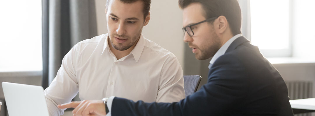 two men looking at laptop screen