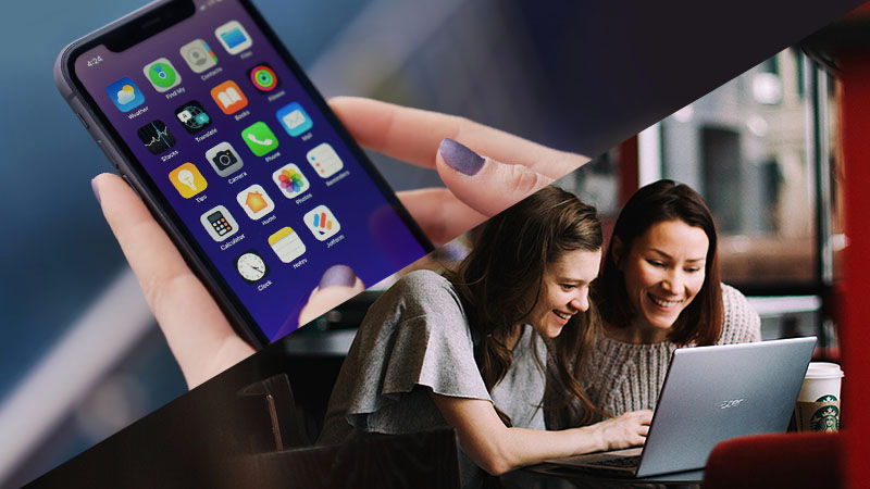 two women smiling at laptop screen