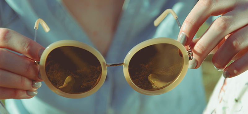 Close up of sunglasses held by woman 