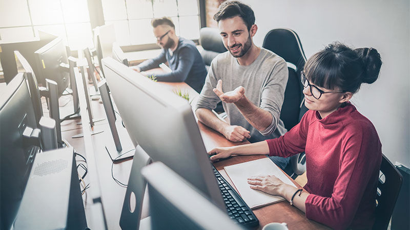 man and woman looking at computer screen