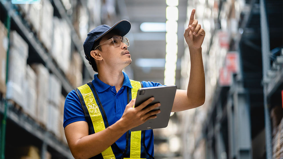 Man holding a tablet and pointing upwards