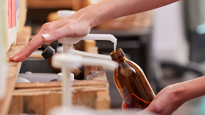 hand pumping lotion into a bottle