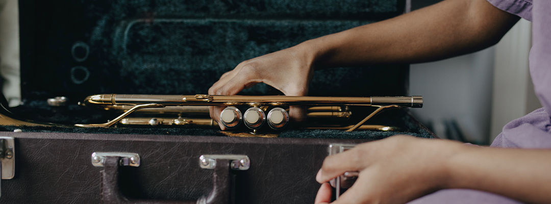 woman placing trumpet in case