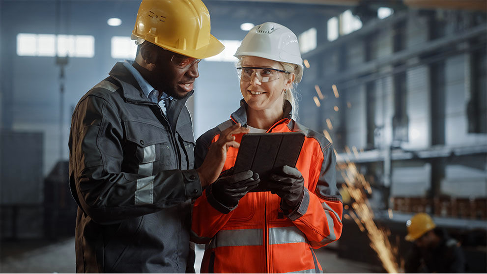 man and woman in warehouse looking at tablet screen