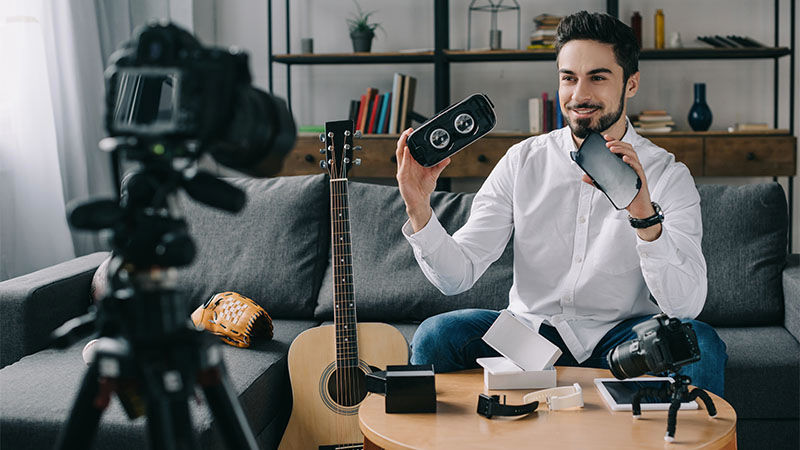 man holding items smiling at camera