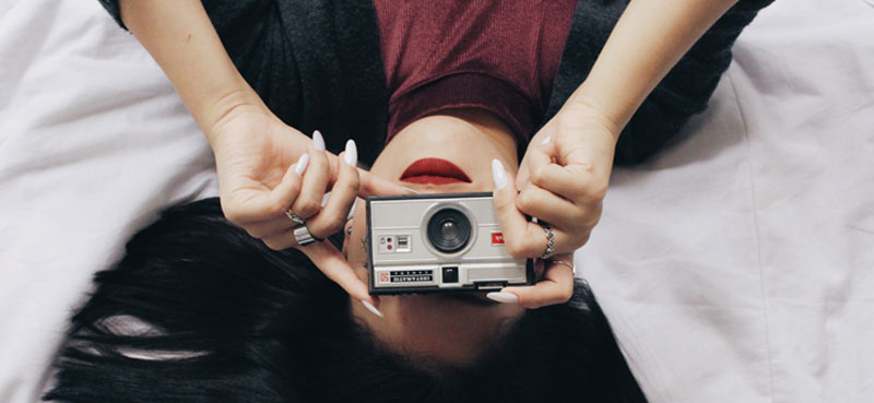 Woman laying upside down with camera