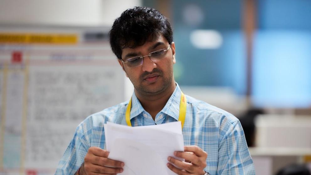 dhl staff checking export documents before shipping goods overseas from bangladesh