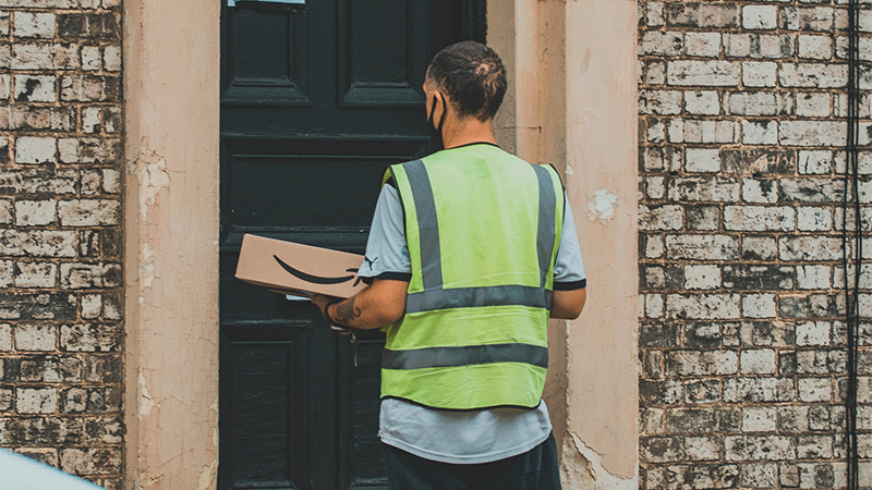 delivery person holding amazon package