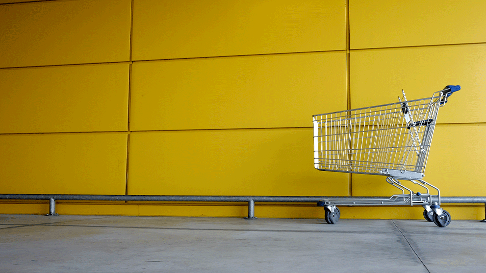 shopping cart against a yellow wall