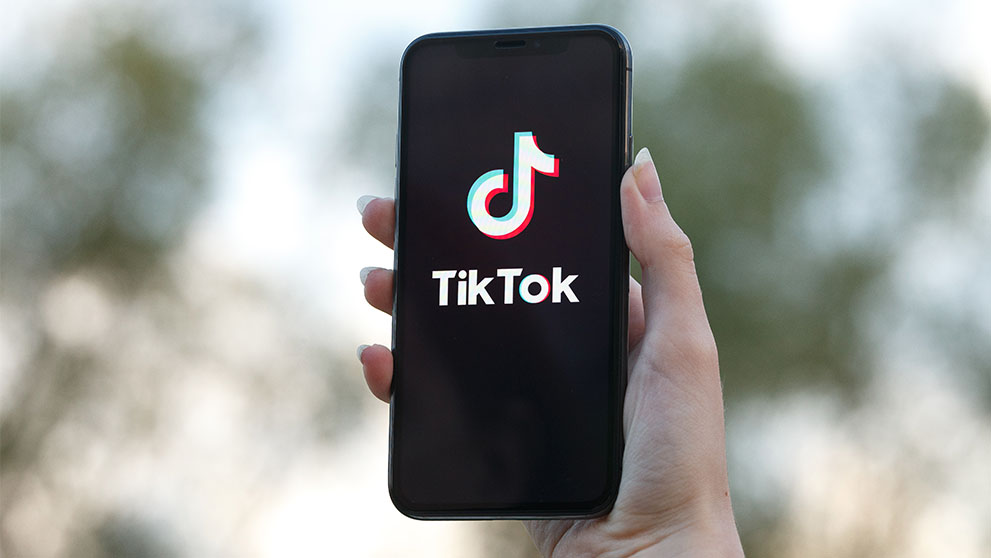 hand holding a mobile phone with tik tok logo on screen