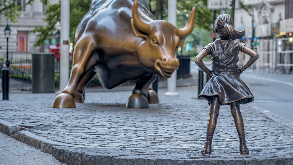Fearless Girl' stature with girl with hands on her hips facing a bull