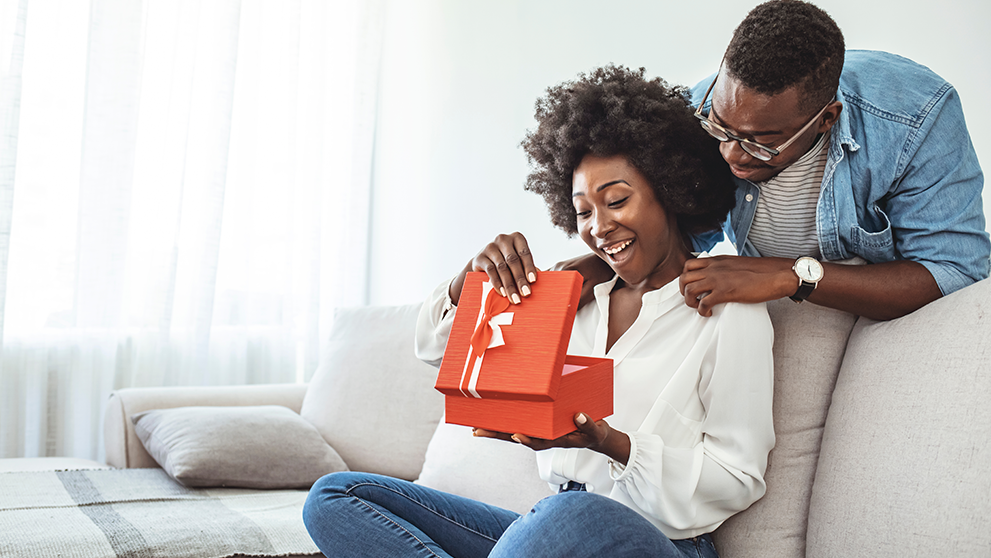 man with woman opening gift