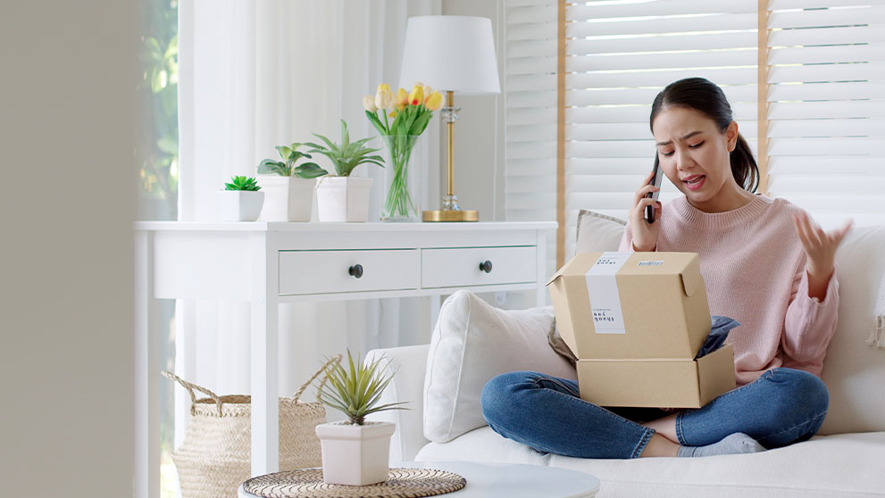 woman speaking on a phone looking into a box