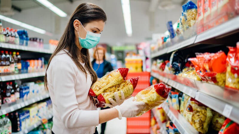 a woman in a supermarket wearing mask and gloves