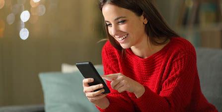 smiling woman looking at mobile phone screen