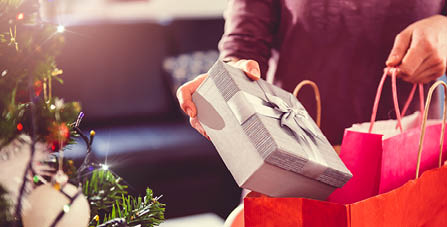 person placing presents in a paper bag
