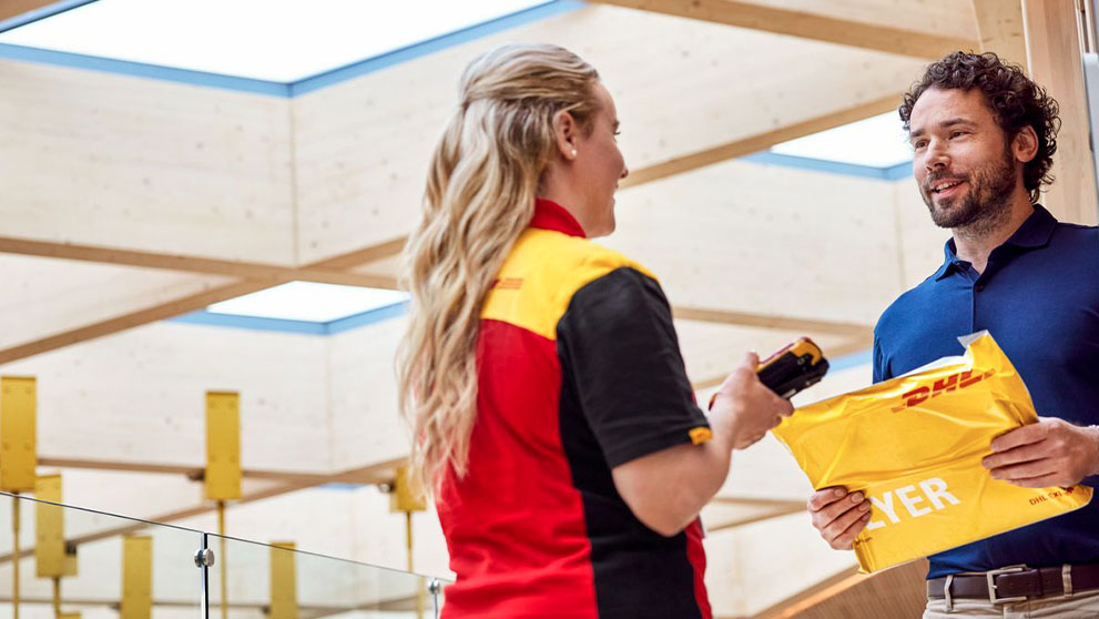 DHL delivery woman handing over a parcel to a man