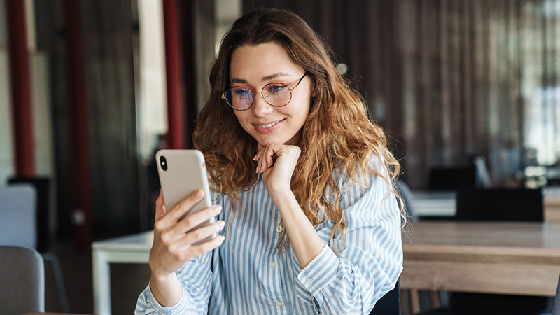 woman smiling at mobile phone