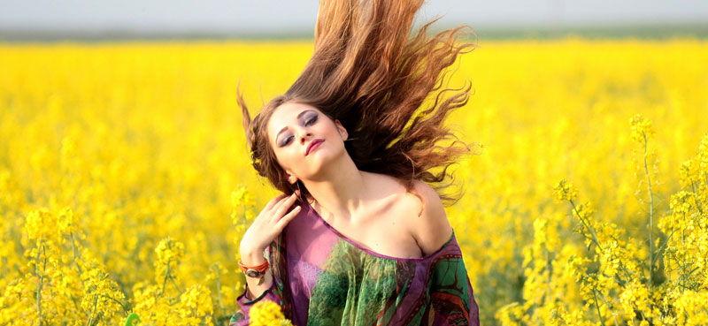 Girl with long flowing hair in yellow field