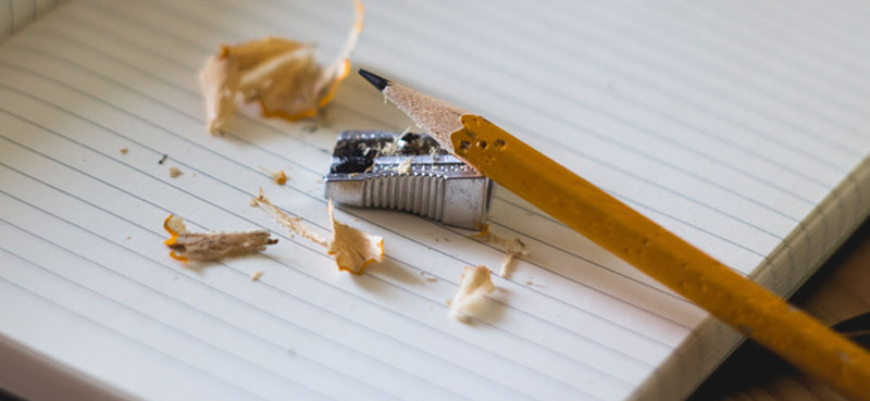 Pencil with sharpener and shavings on notepad