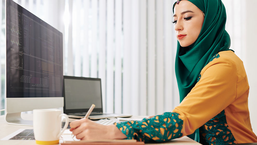 woman in hijab writing