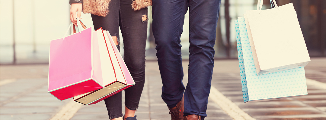 two people holding shopping bags
