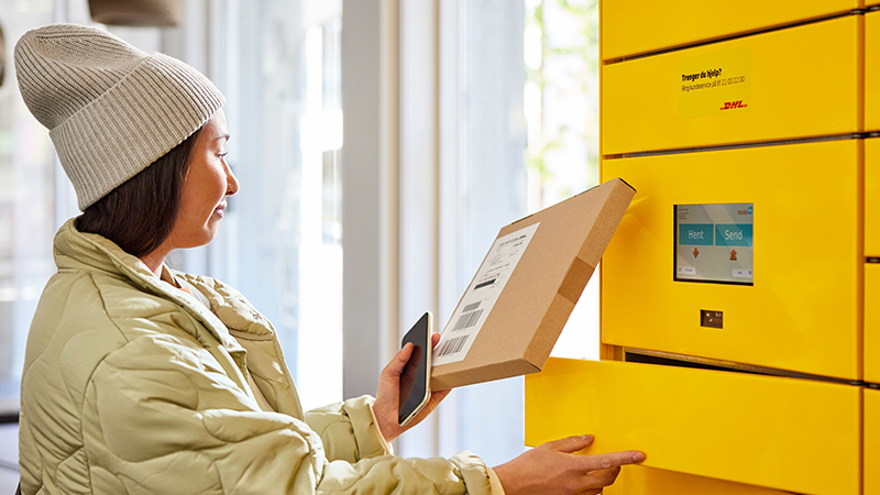 woman placing parcel in parcel locker