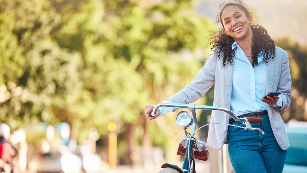 woman smiling holding a bicycle