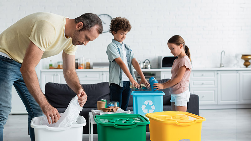 man and two kids recycling items