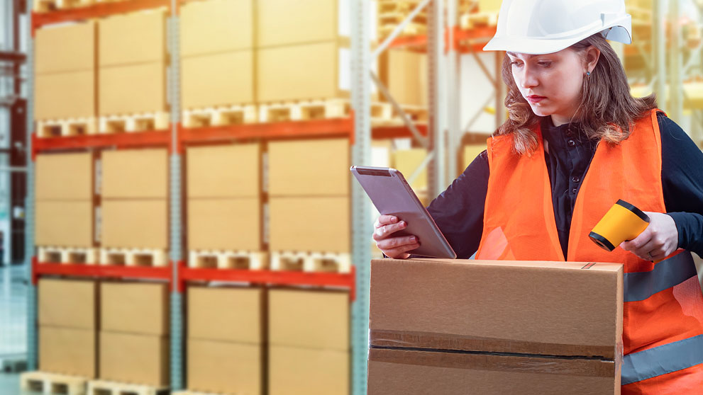woman in warehouse looking at tablet screen