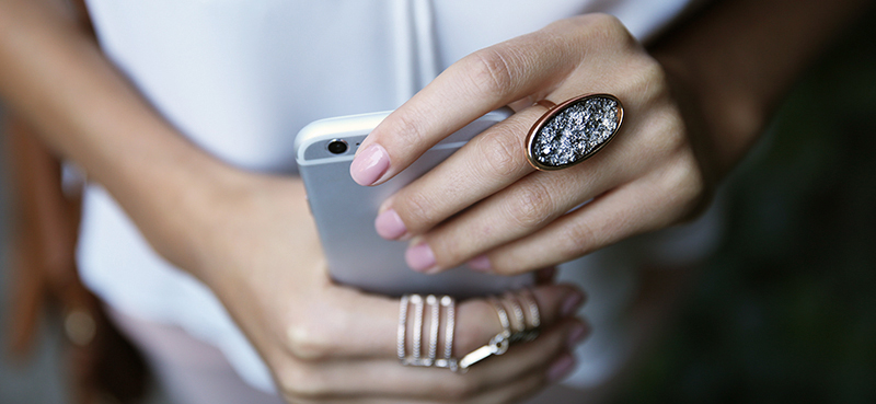 Woman holding her Iphone with rings around her fingers 